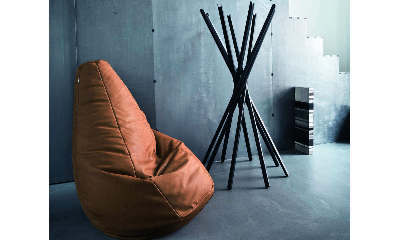 Fauteuil Sacco de Zanotta disposé dans un intérieur. Housse contenant de petites billes de polystyrène à grande résistance et possédant un revêtement en cuir marron.