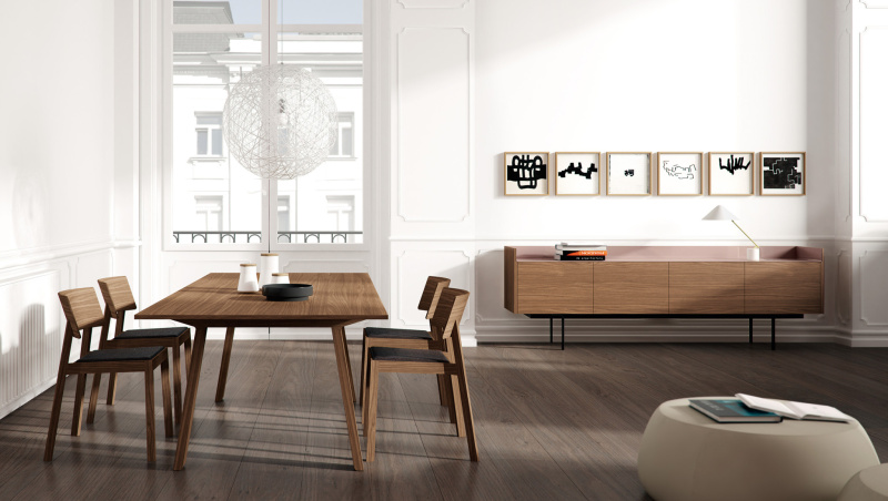 Buffet rangement Stockholm de Punt disposé dans une salle à manger lumineuse. La structure de meuble est en bois avec un placage en bois de noisetier (SUPER-MATT WALNUT). Le plateau ainsi que les pieds sont en métal, noir pour le piètement et rose pal pour le plateau.